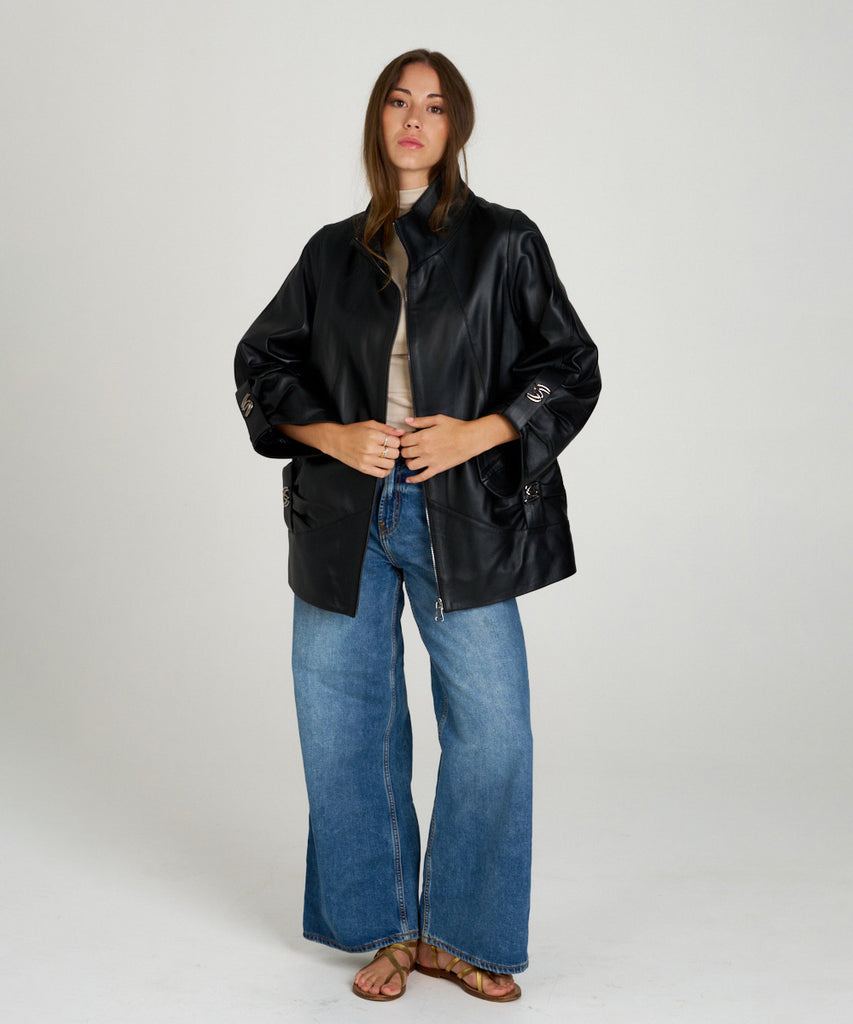 Chaqueta de piel negra para mujer con hebillas metálicas. Diseño moderno y elegante en napa suave. Perfecta para un estilo sofisticado y urbano.
