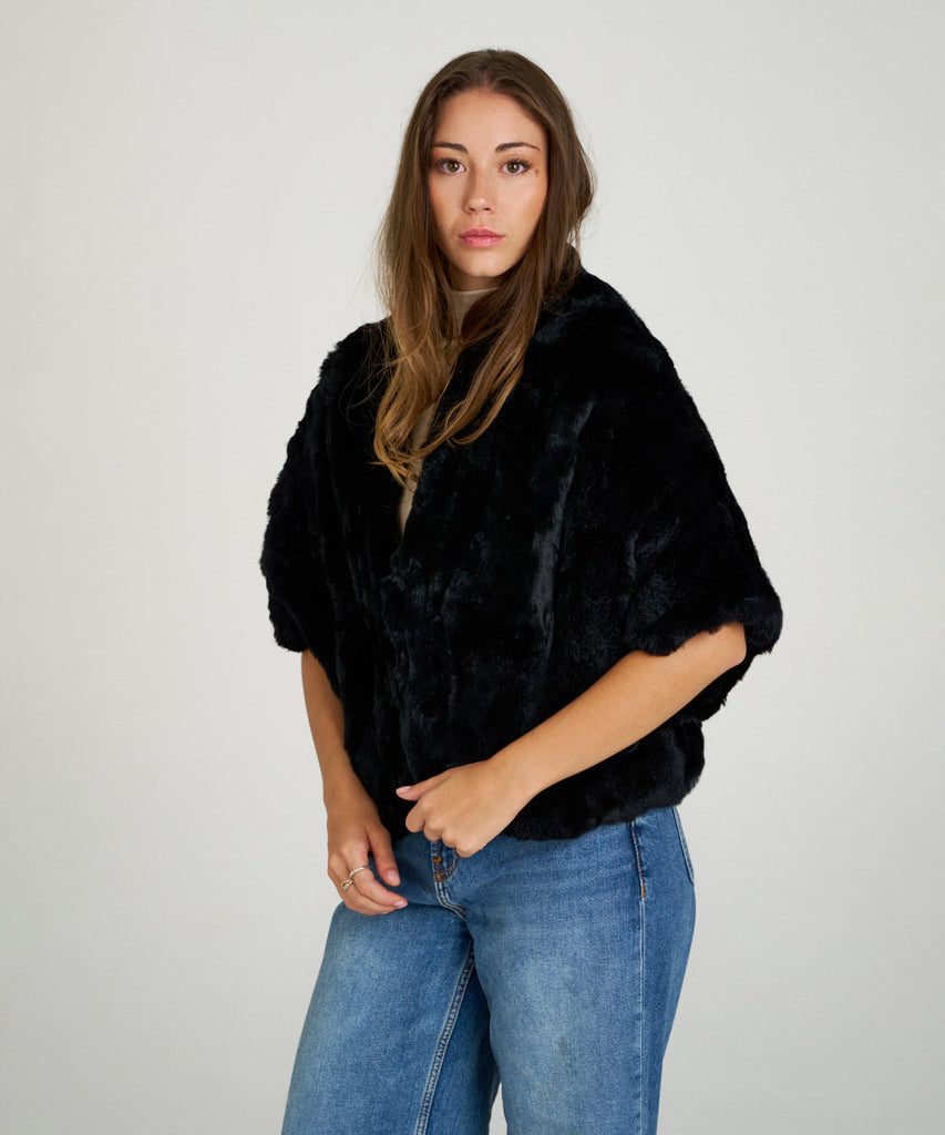 Capa corta de piel de rex negro de Hervás Piel, diseño artesanal de peletería española con manga francesa y cierre oculto.