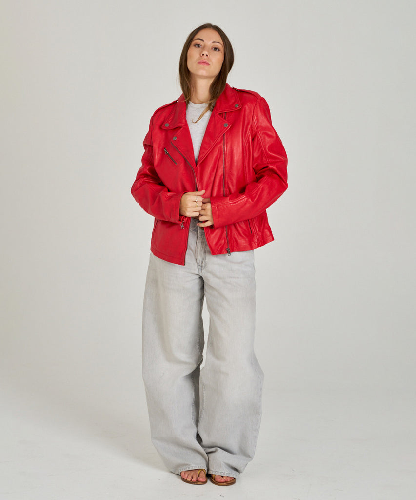 Cazadora biker de piel roja para mujer de HervásPiel, diseño con cremallera asimétrica y solapas clásicas.
