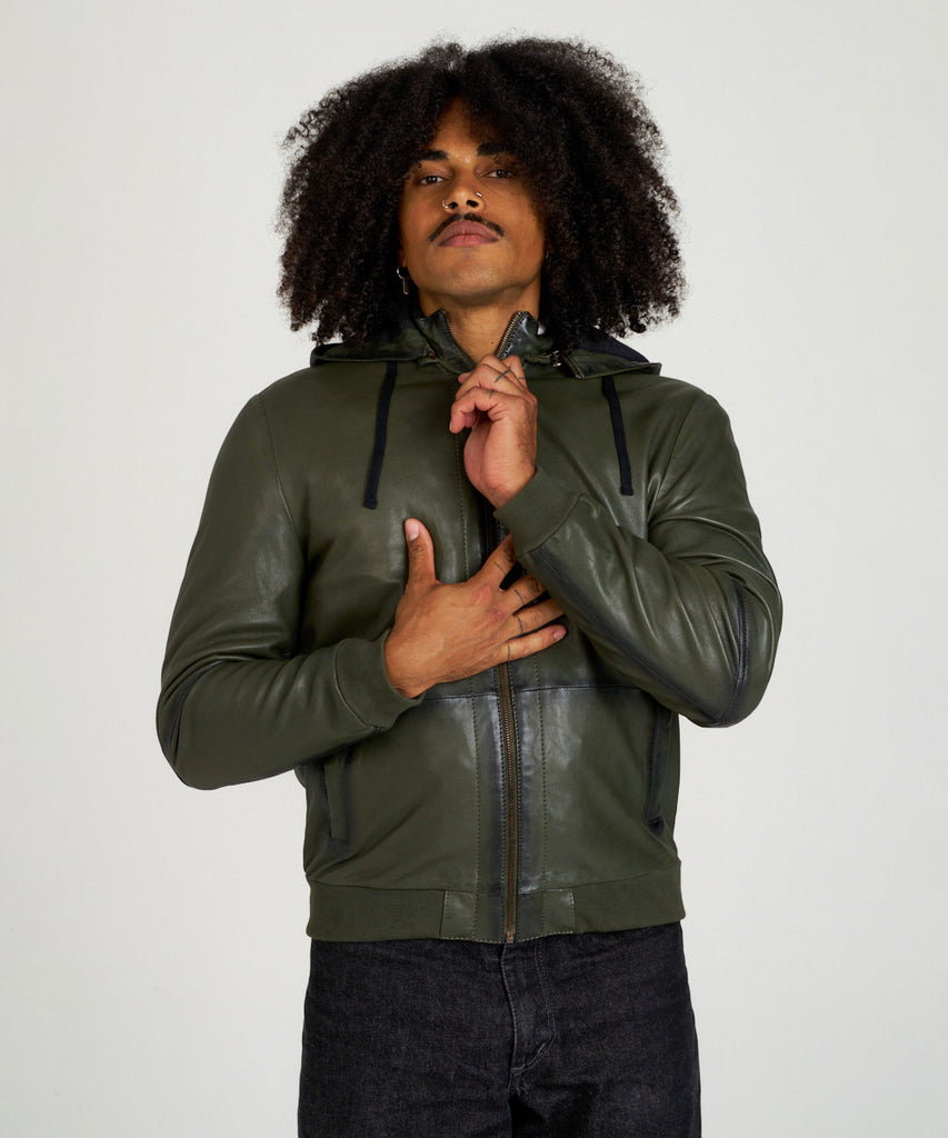 Cazadora bomber de piel verde oliva con capucha, cierre de cremallera y puños elásticos, estilo moderno y urbano.
