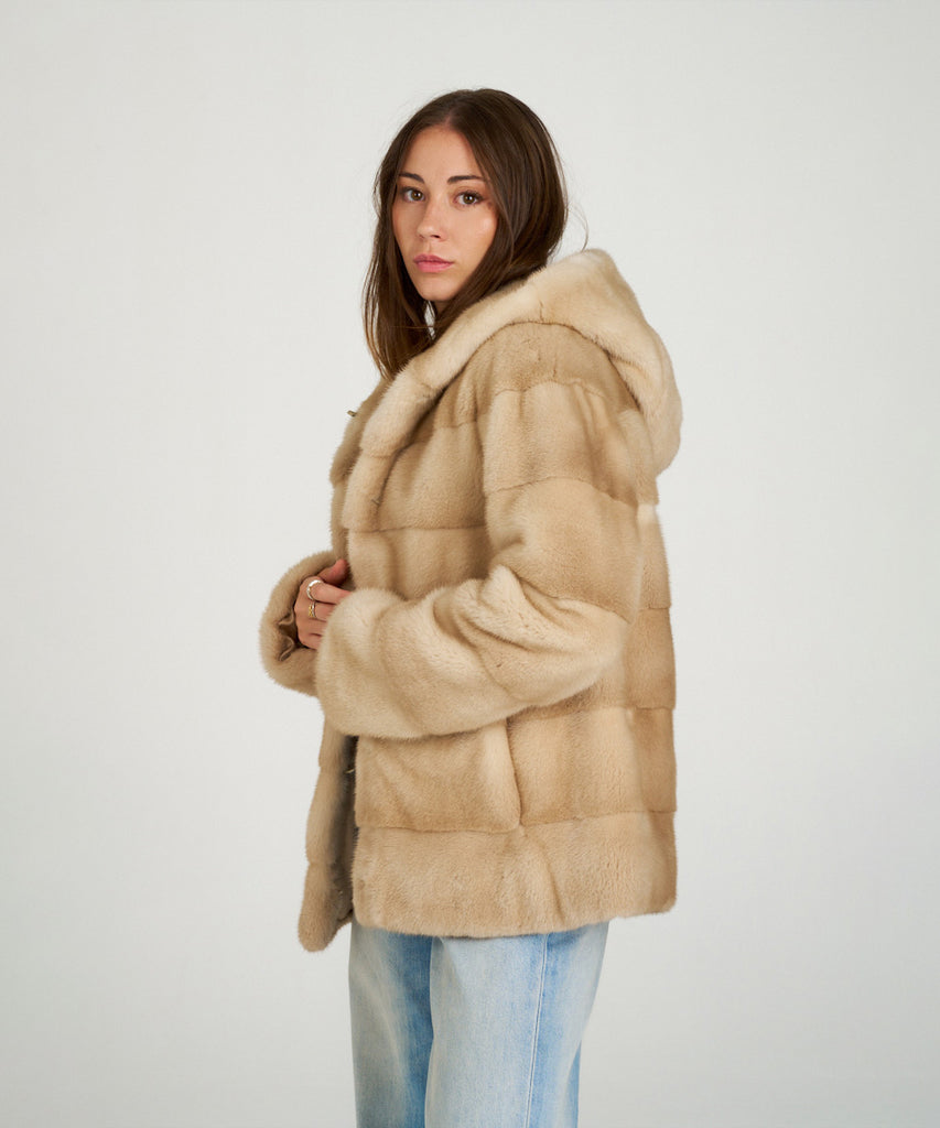 Cazadora de visón en color arena. Piel natural de alta calidad con capucha y cierre oculto. Elegancia, suavidad y calidez en una prenda exclusiva.