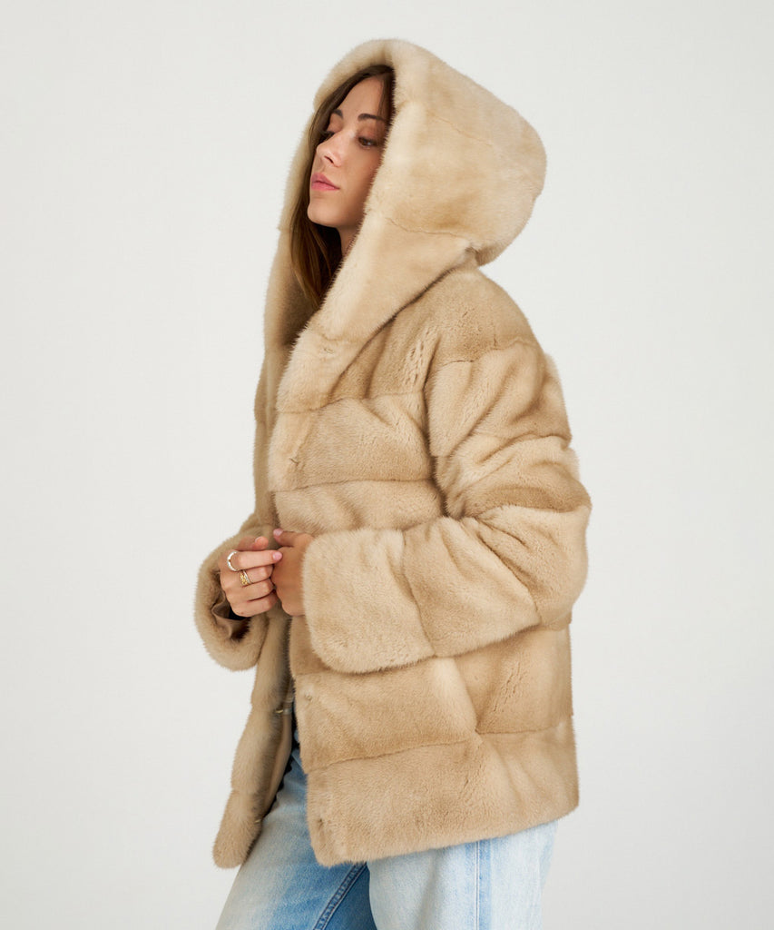 Cazadora de visón en color arena. Piel natural de alta calidad con capucha y cierre oculto. Elegancia, suavidad y calidez en una prenda exclusiva.