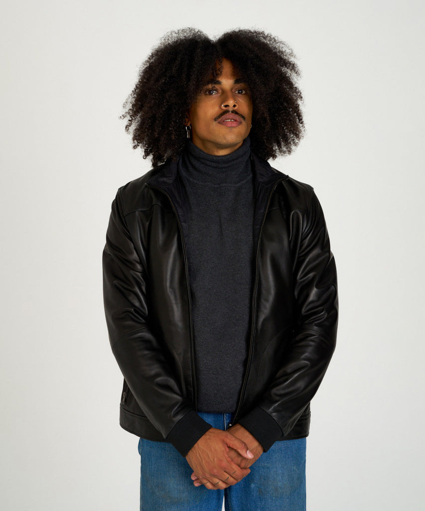 Cazadora reversible de piel napa negra con interior técnico y cremallera.