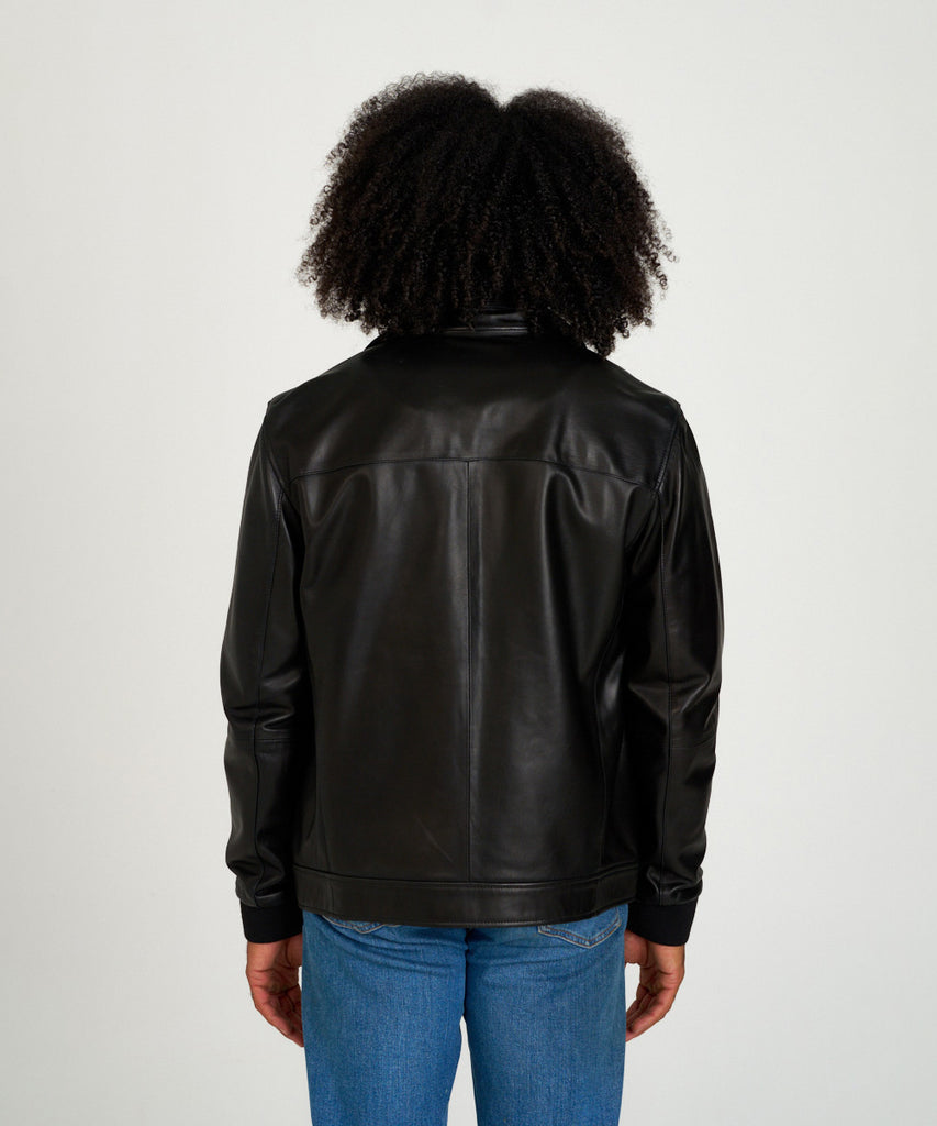 Cazadora reversible de piel napa negra con interior técnico y cremallera.