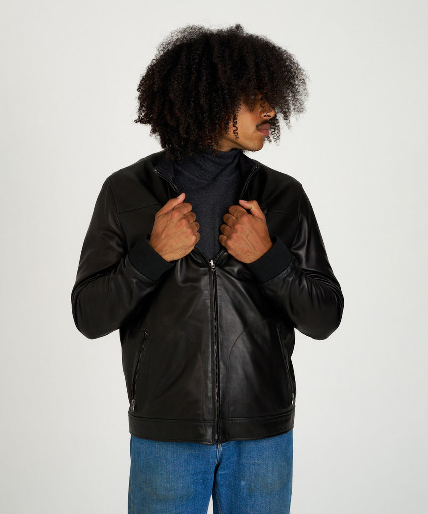 Cazadora reversible de piel napa negra con interior técnico y cremallera.