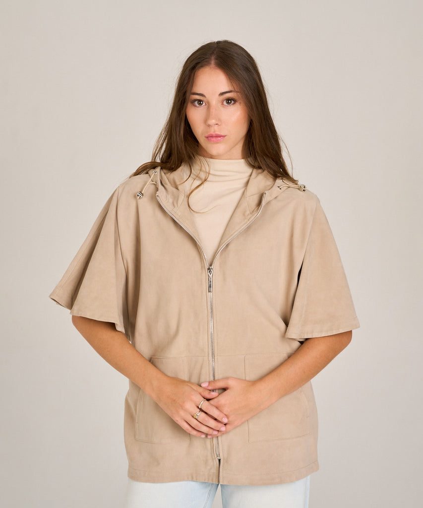 Chaqueta de ante color arena con capucha y manga corta. Diseño relajado, suave y versátil, perfecta para entretiempo.