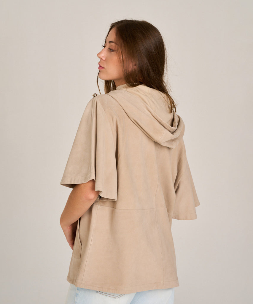 Chaqueta de ante color arena con capucha y manga corta. Diseño relajado, suave y versátil, perfecta para entretiempo.