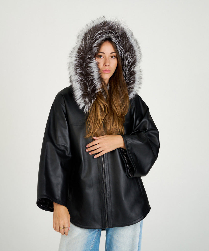 Chaqueta de piel negra para mujer con capucha de piel de pelo natural. Diseño oversize elegante y cálido. Sofisticación y confort en cada detalle.