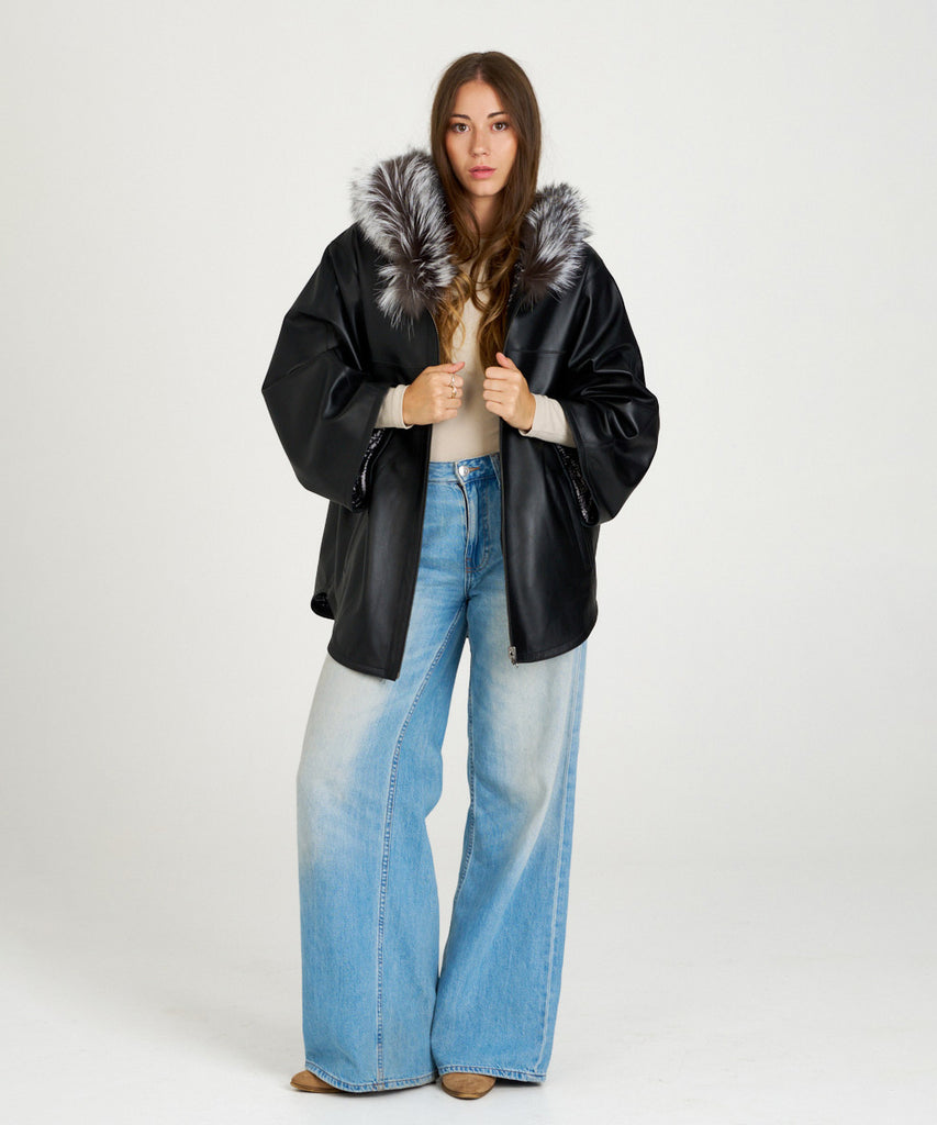 Chaqueta de piel negra para mujer con capucha de piel de pelo natural. Diseño oversize elegante y cálido. Sofisticación y confort en cada detalle.