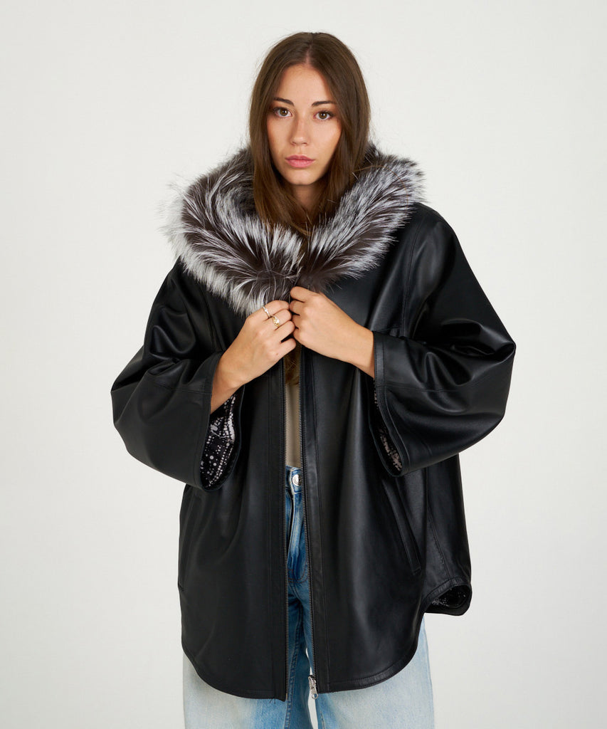 Chaqueta de piel negra para mujer con capucha de piel de pelo natural. Diseño oversize elegante y cálido. Sofisticación y confort en cada detalle.