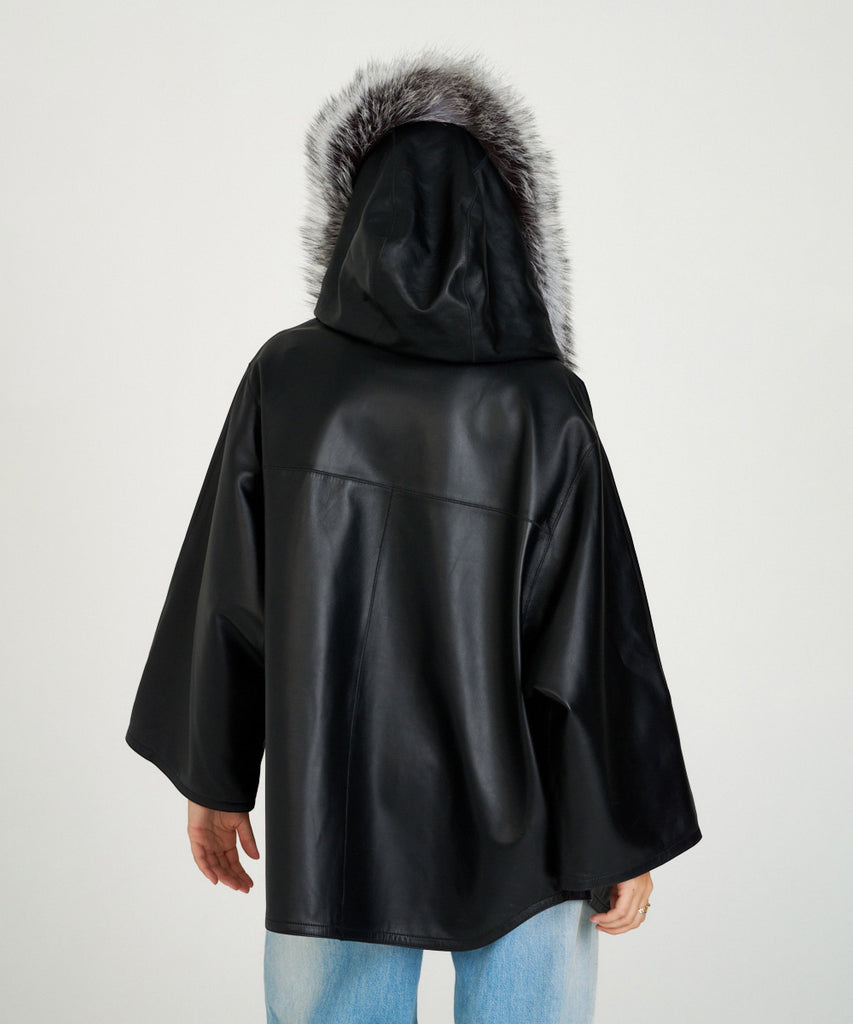 Chaqueta de piel negra para mujer con capucha de piel de pelo natural. Diseño oversize elegante y cálido. Sofisticación y confort en cada detalle.