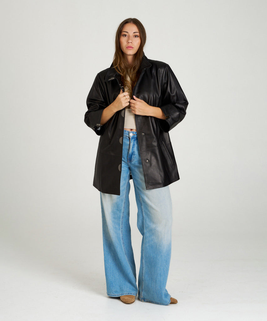 Chaqueta de piel negra para mujer. Diseño moderno con manga tres cuartos y botones a presión. Ligera, elegante y muy versátil.