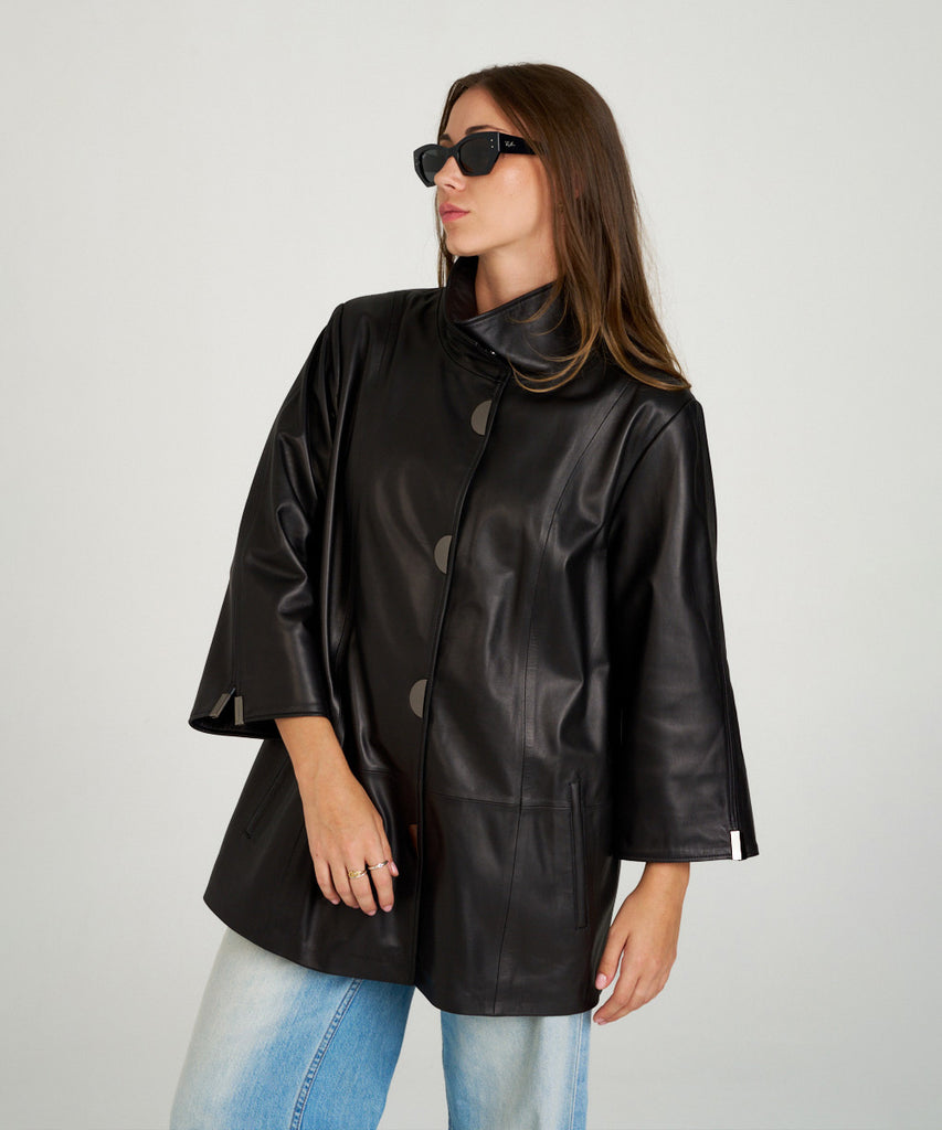 Chaqueta de piel negra para mujer. Diseño moderno con manga tres cuartos y botones a presión. Ligera, elegante y muy versátil.