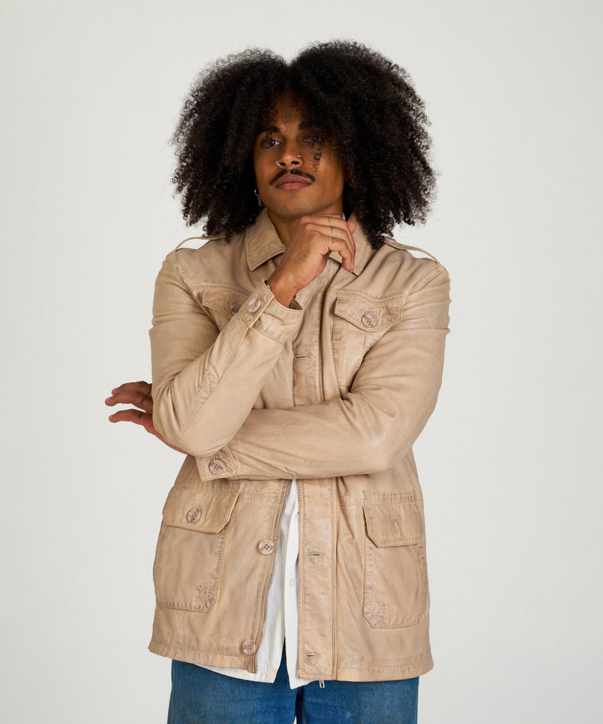 Chaqueta sahariana de piel color arena para hombre HervásPiel, con bolsillos frontales, cierre de cremallera y tapeta con botones.