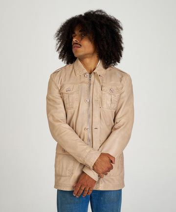 Chaqueta sahariana de piel color arena para hombre HervásPiel, con bolsillos frontales, cierre de cremallera y tapeta con botones.