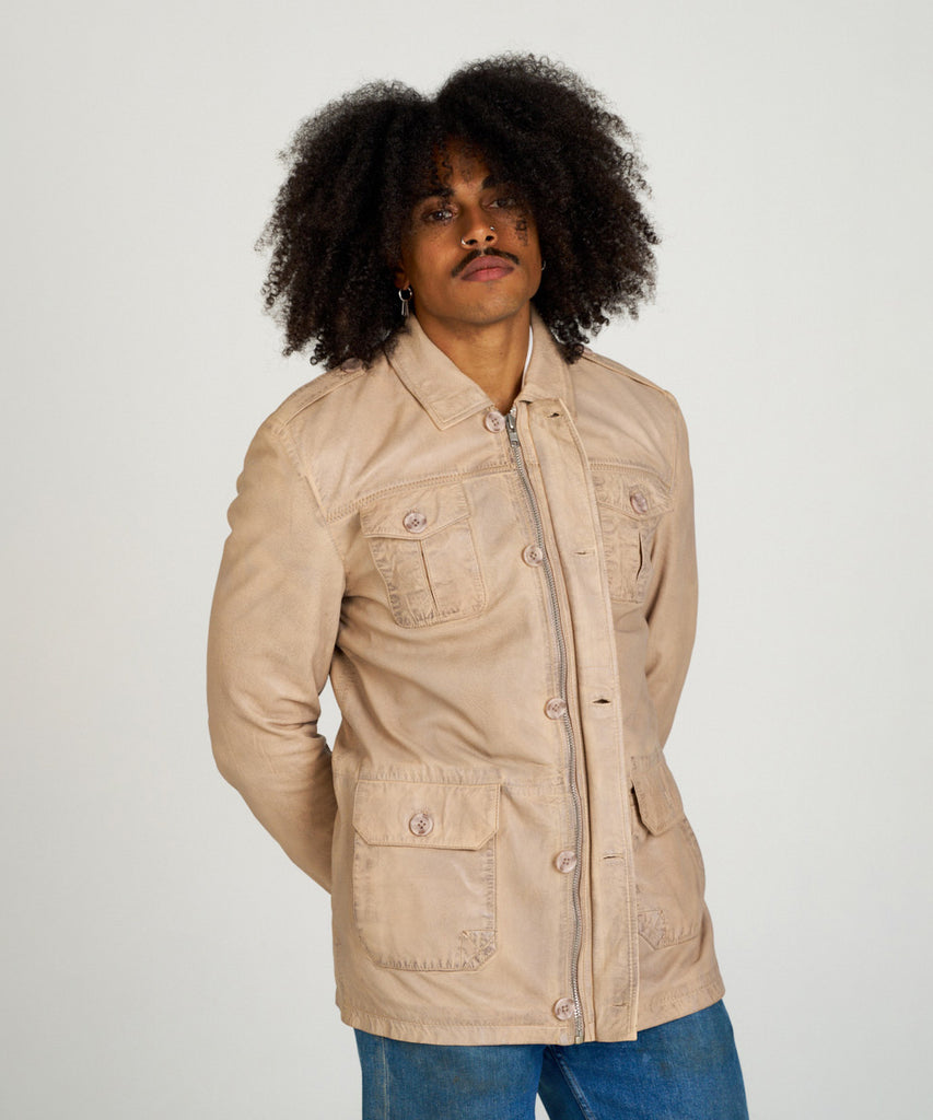 Chaqueta sahariana de piel color arena para hombre HervásPiel, con bolsillos frontales, cierre de cremallera y tapeta con botones.