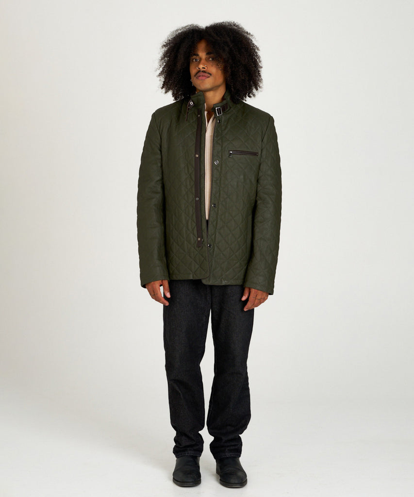 Chaqueta acolchada verde de piel con cuello alto y hebilla, estilo urbano y elegante.