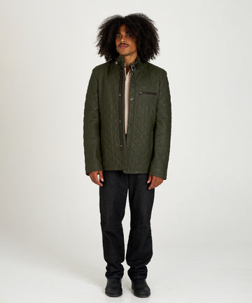 Chaqueta acolchada verde de piel con cuello alto y hebilla, estilo urbano y elegante.