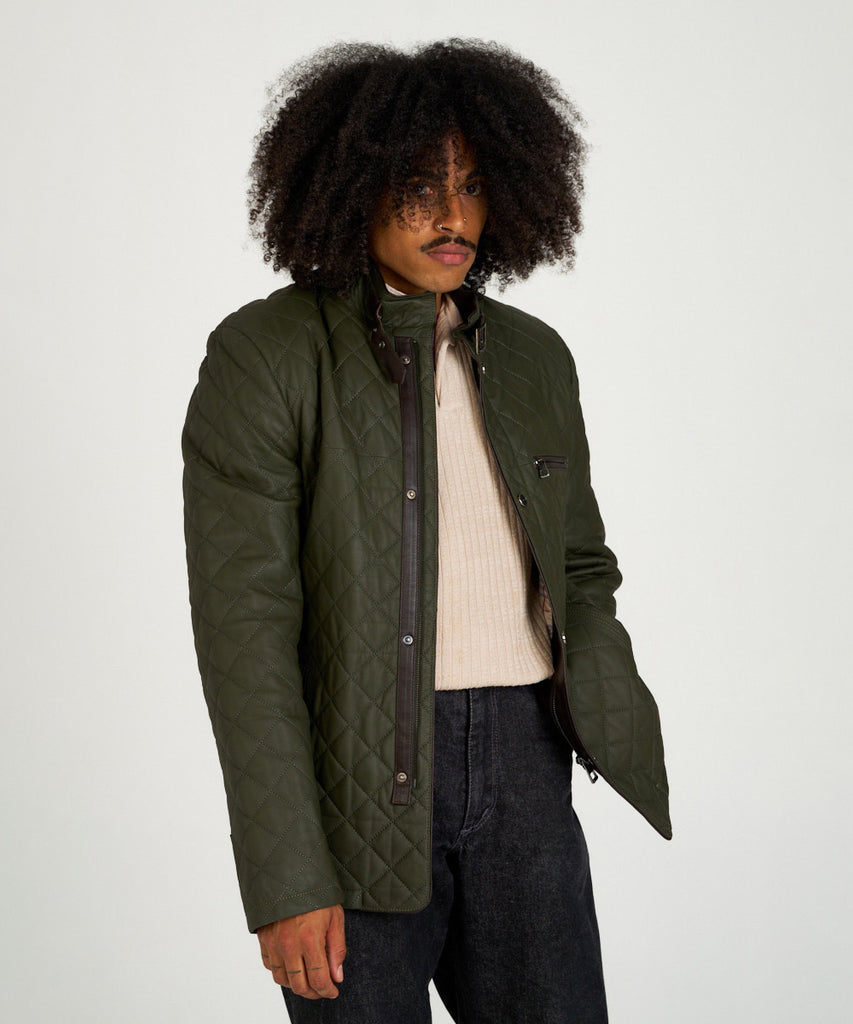 Chaqueta acolchada verde de piel con cuello alto y hebilla, estilo urbano y elegante.