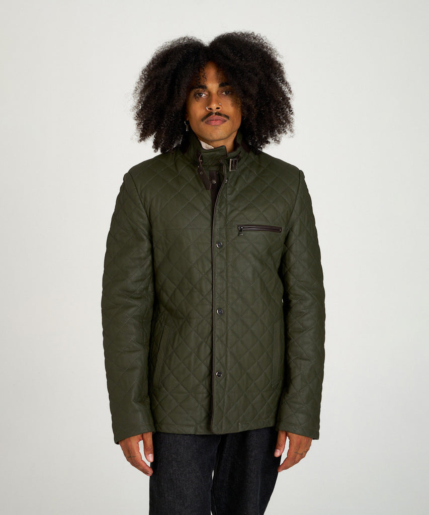 Chaqueta acolchada verde de piel con cuello alto y hebilla, estilo urbano y elegante.